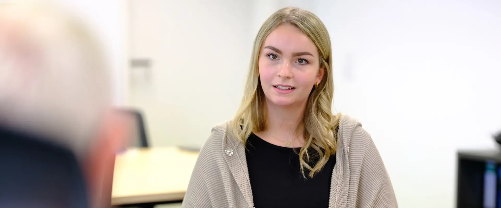 Beratungsgespräch zwischen einer jungen, blonden Patientin und ihrem Arzt