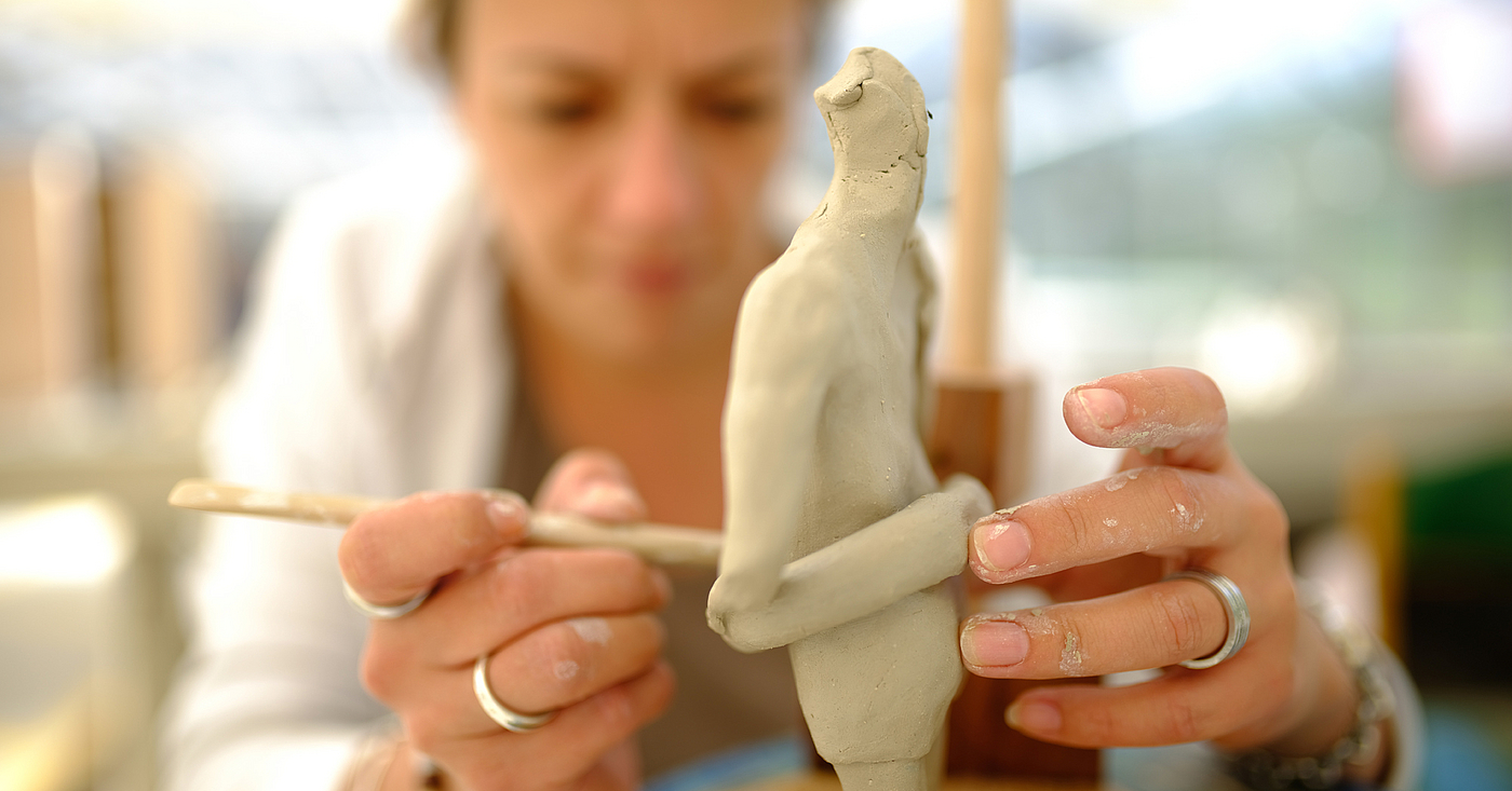Eine Klientin gestaltet einen Figur aus Ton