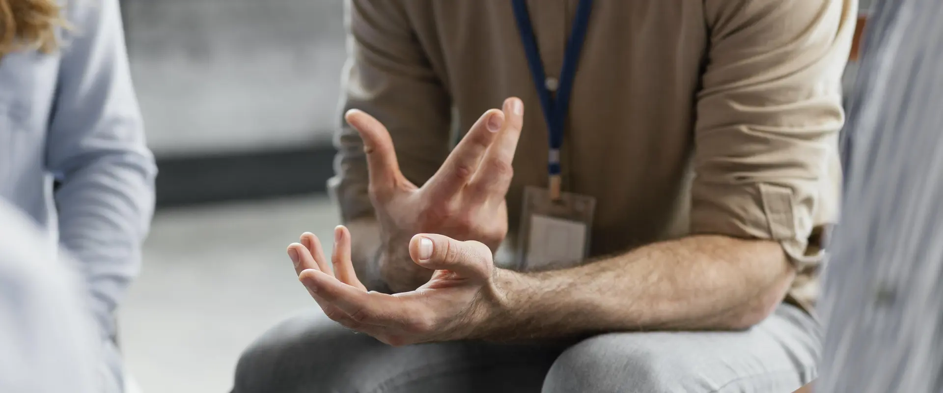 Mann gestikuliert während deiner Gruppentherapie. Man sieht nur den Unterkörper