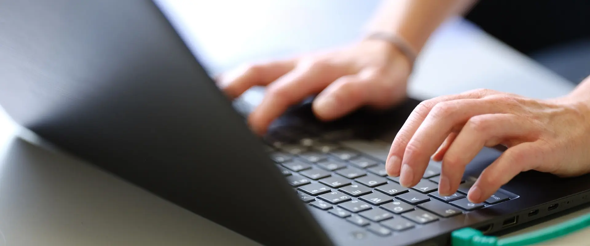 Nahaufnahme schwarzes Notebook, mit Händen